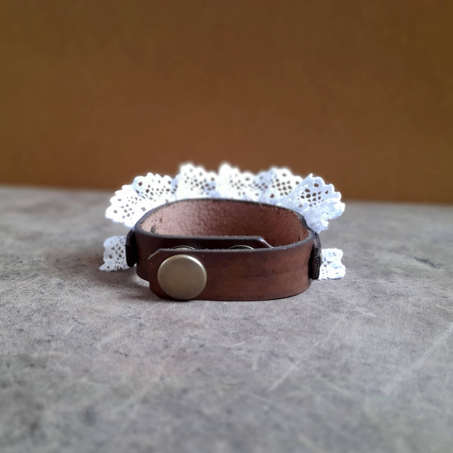 Detailed view of the stainless steel snap buttons with matching antique bronze caps on The Prairie Lace Cuff, showing the adjustable fit.