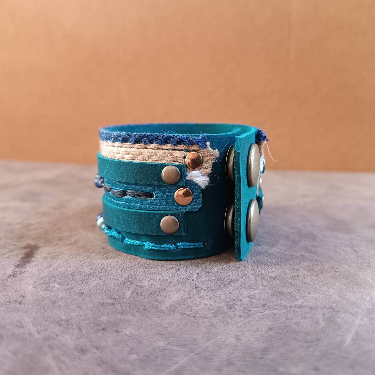 Close-up of the adjustable antique bronze snap fasteners on The Protector Cuff, showing the secure closure designed for a customizable fit.