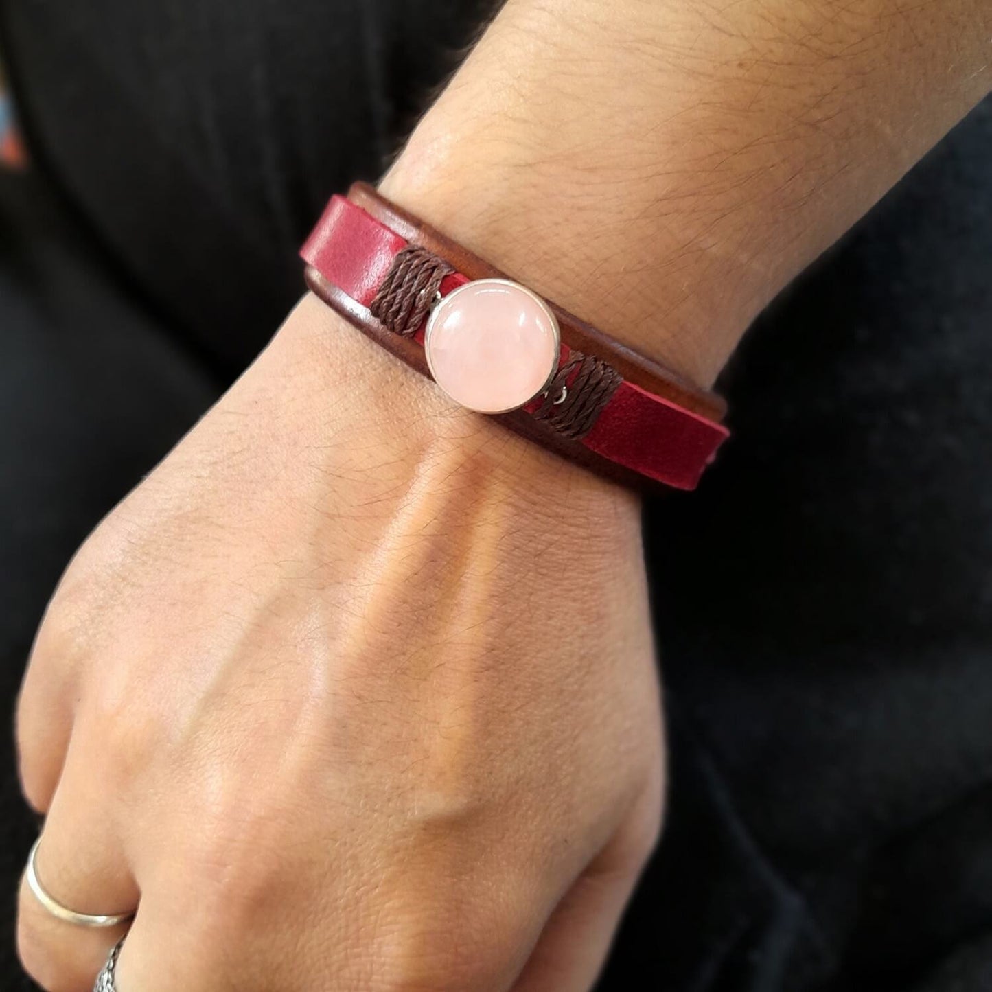 The Red Leather Bracelet with Natural Rose Quartz worn on a wrist, demonstrating its comfortable fit and vibrant, sensual style.