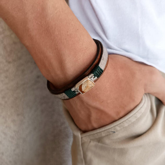 The Silent Witness Bracelet worn on a man's wrist, highlighting its earthy elegance, layered leather textures, and the distinctive Picture Jade stone, complementing everyday style.