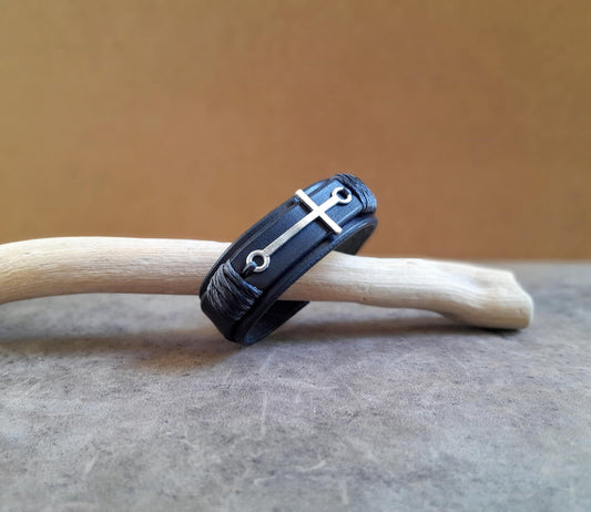 The Steadfast Spirit Cross Bracelet, all-black version, side view. Features a large horizontal stainless steel silver cross on a dual-layered black full-grain leather band.