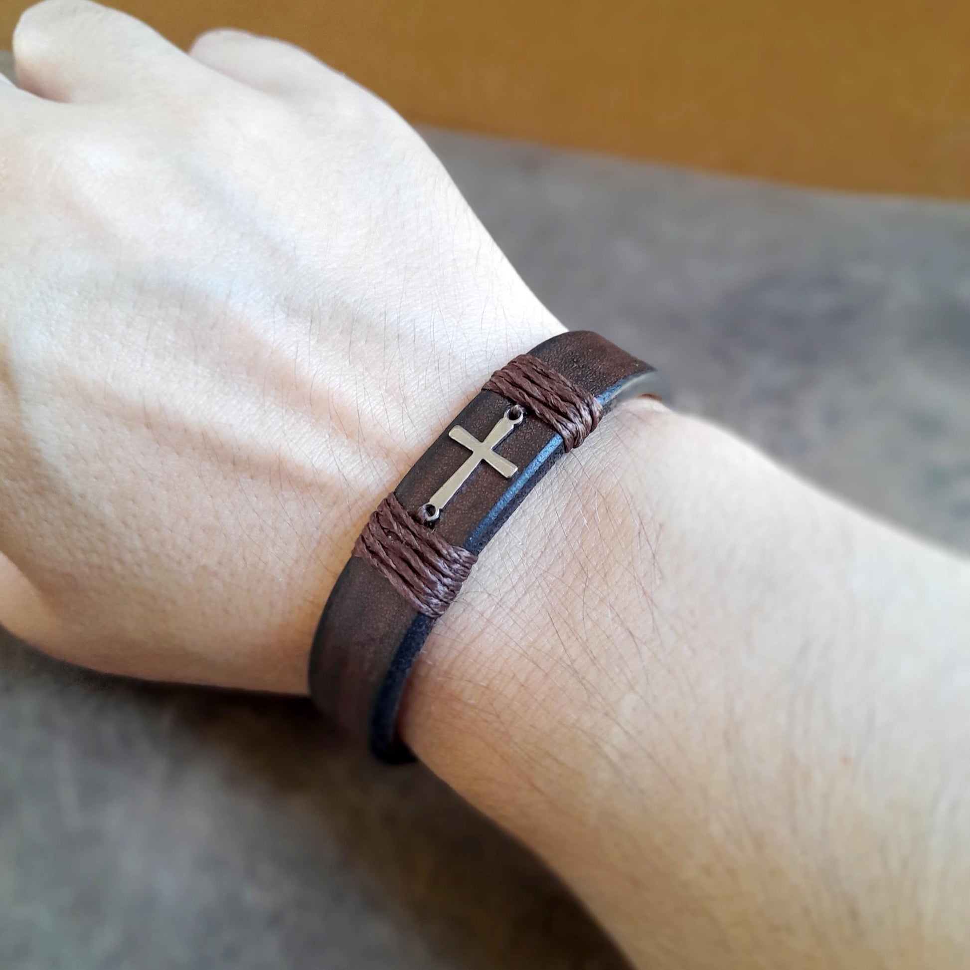 The Subtle Cross Bracelet worn solo on a wrist, showcasing its clean lines and comfortable fit for everyday style.