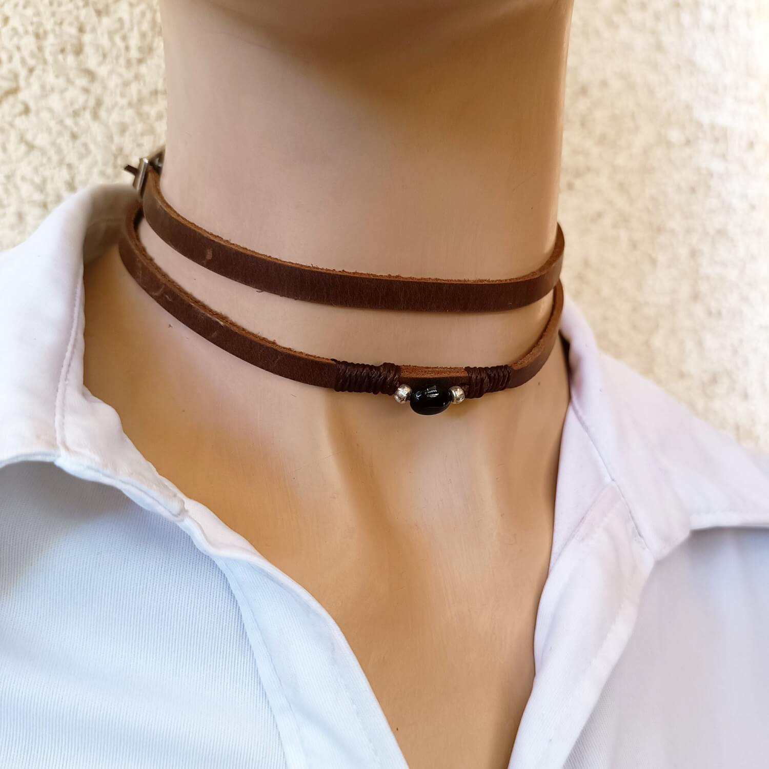 The Wanderer's Wrap worn as a double-wrap choker necklace with different, more loose adjusting, showing the dark brown Crazy Horse leather and the Black Tourmaline stone resting on the neck.