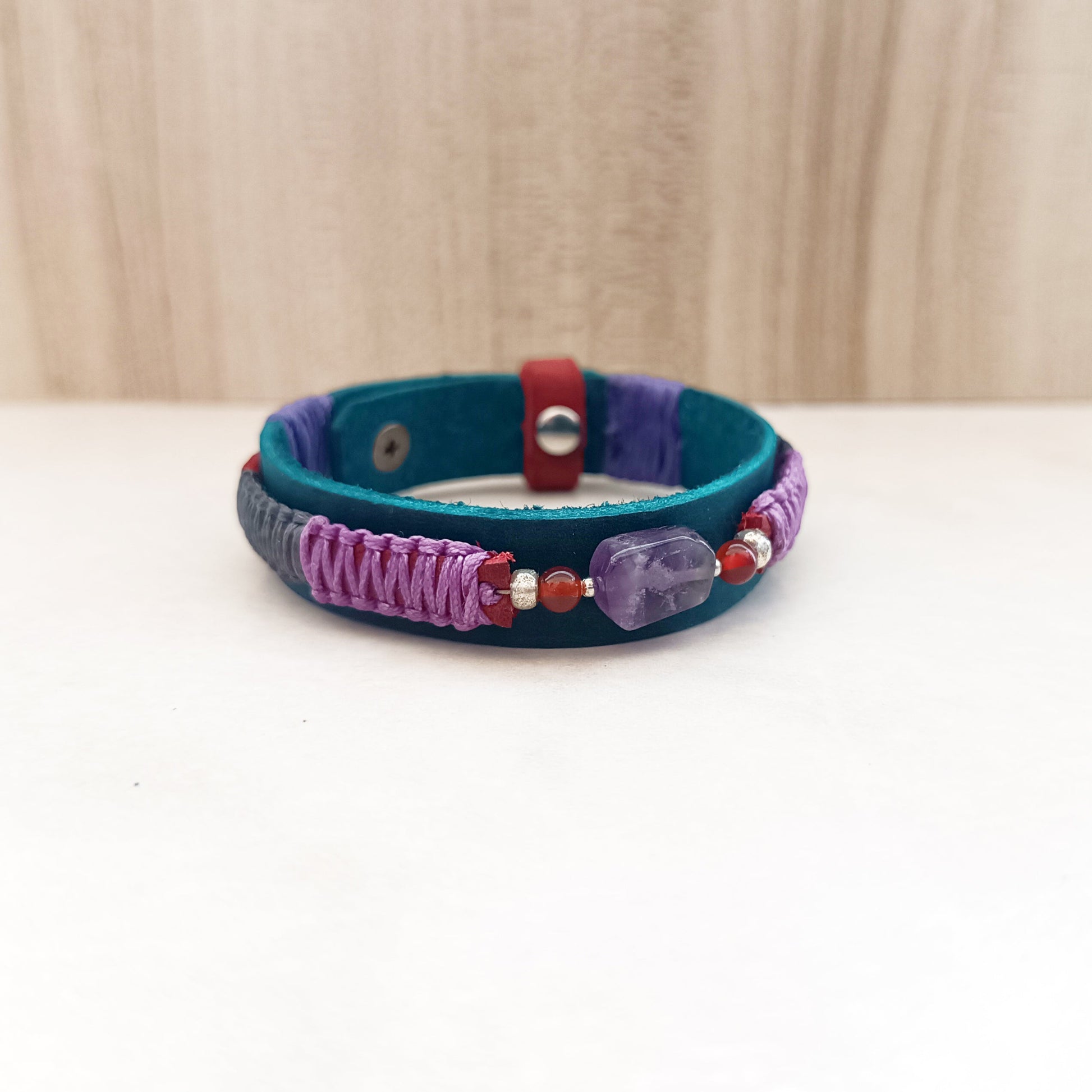 Amethyst gemstone bracelet with purple and grey braid – front view on white marble, showing beautiful contrast