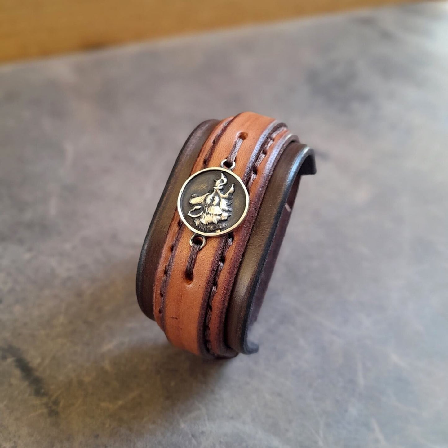 Brown leather bracelet with a brass wild boar charm side view close up