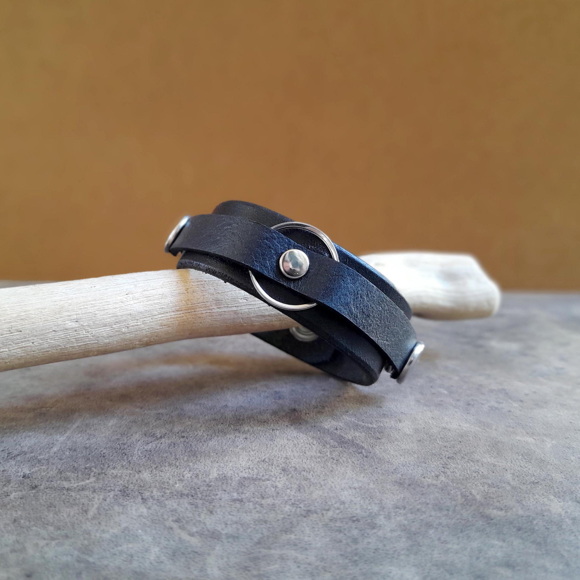 Vachetta Leather Ring Holder Bracelet in black carrying a silver ring.