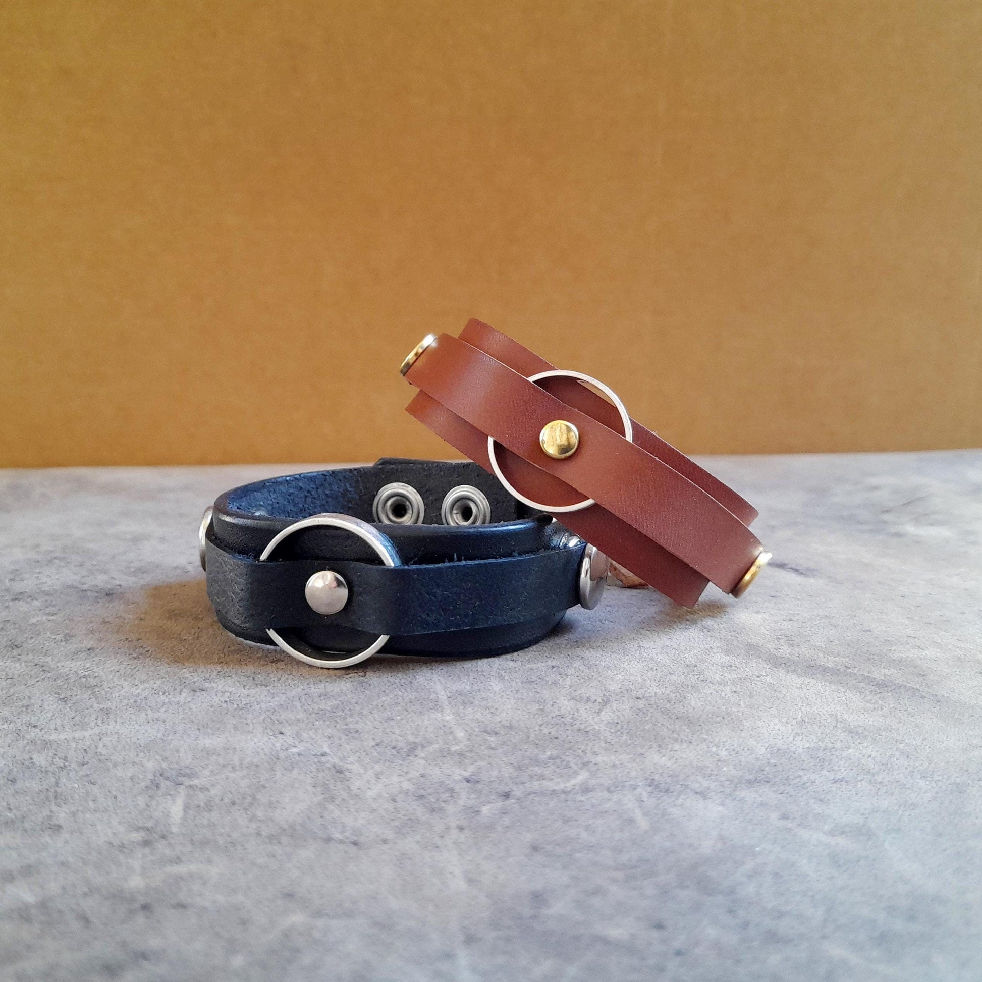 Vachetta Leather Ring Holder Bracelets in black and brown with snap buttons.