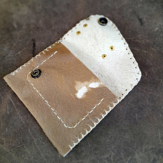 The Hair on Hide Women's Wallet open, revealing two internal compartments for cards, cash, and coins, showcasing its functional design.