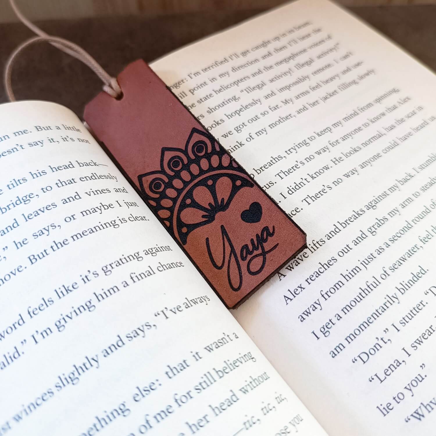 Brown leather bookmark with 'Yaya' engraving on an open book