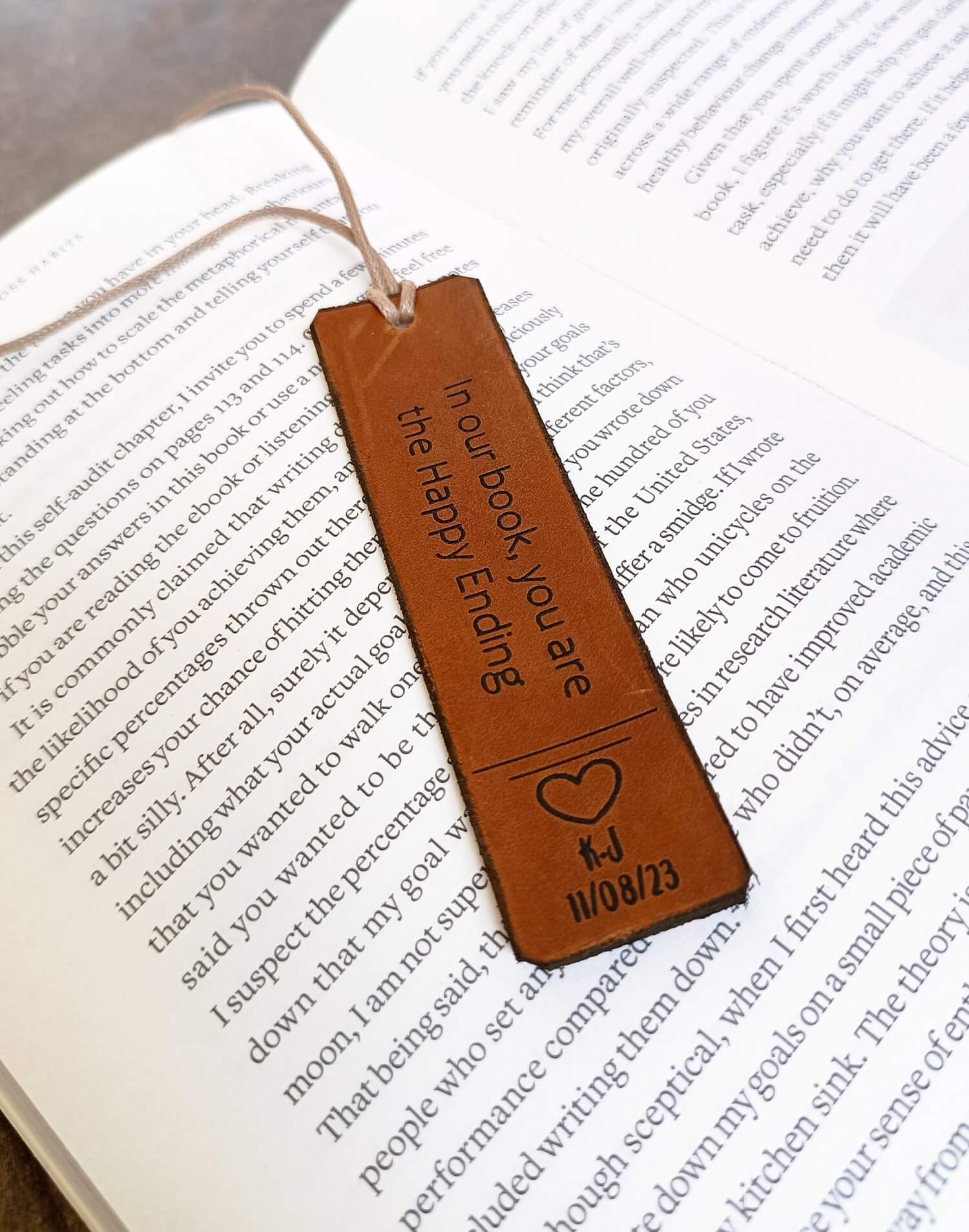 Brown leather bookmark with text and a heart design on an open book