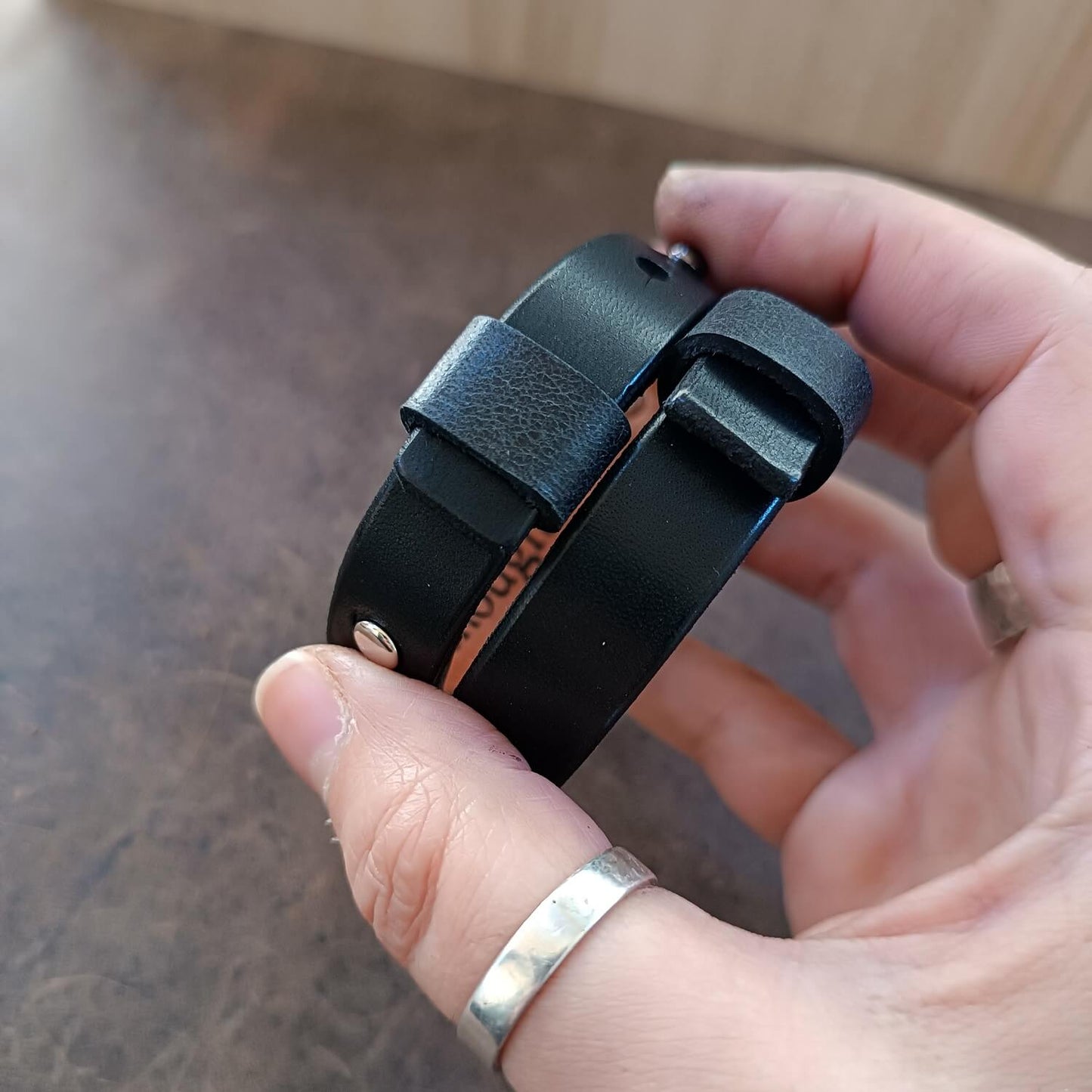 matching loops securing closures on the black watchband style cuffs