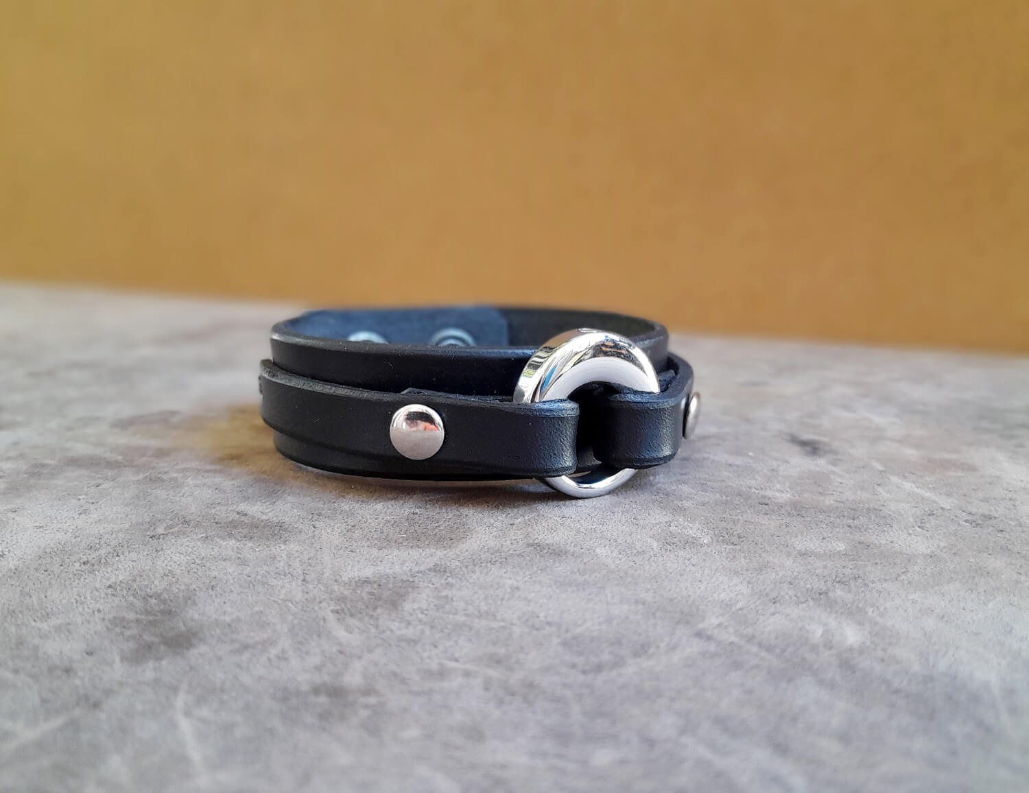 Close up photo of the black leather bracelet variation with the silver stainless steel urn pendant.