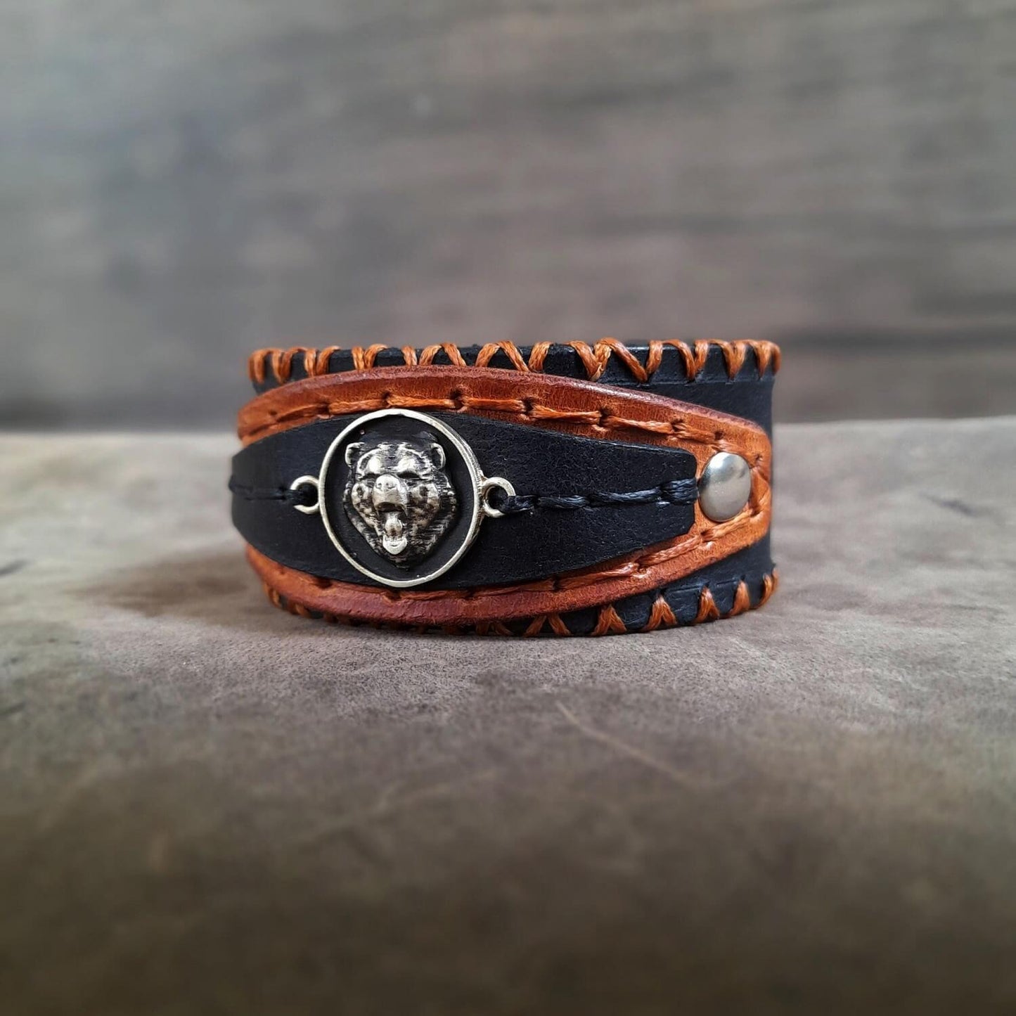 Close-up of brass bear charm, showing detailed craftsmanship and rugged elegance.