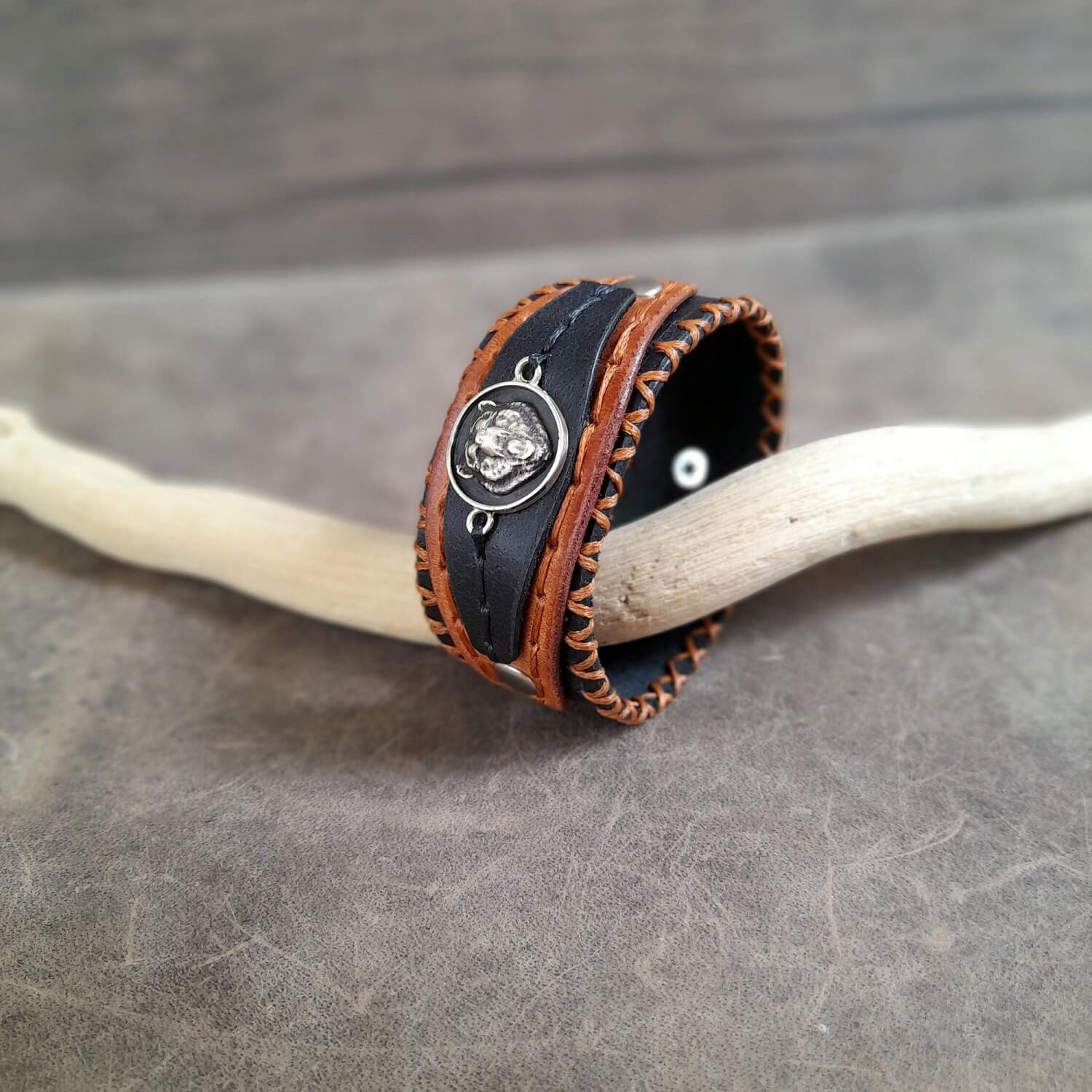 Side angle showing rich leather layers and waxed thread hand-stitching on bear bracelet.