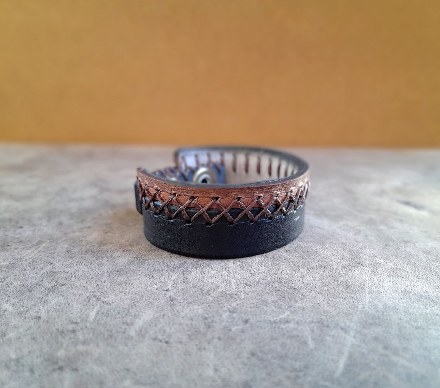 Leather bracelet with woven design on a textured surface