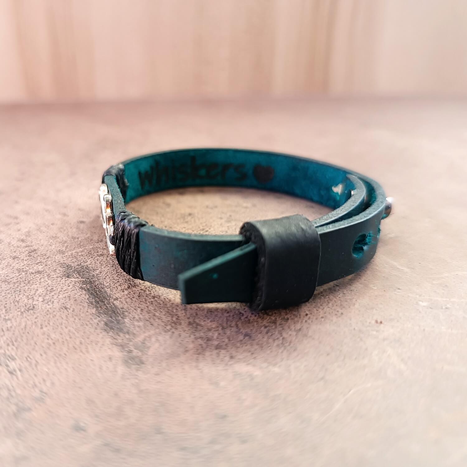 Blue leather bracelet with 'Whiskers' engraved on the underside