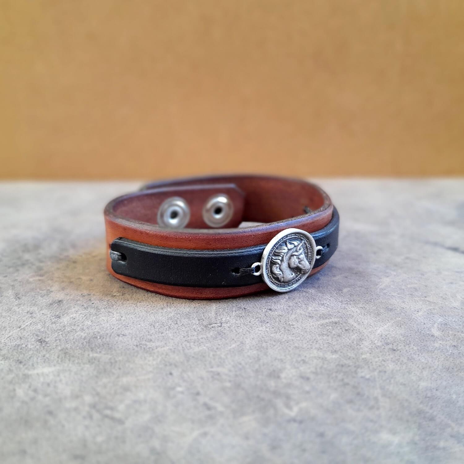 Side profile of layered black and brown leather horse cuff