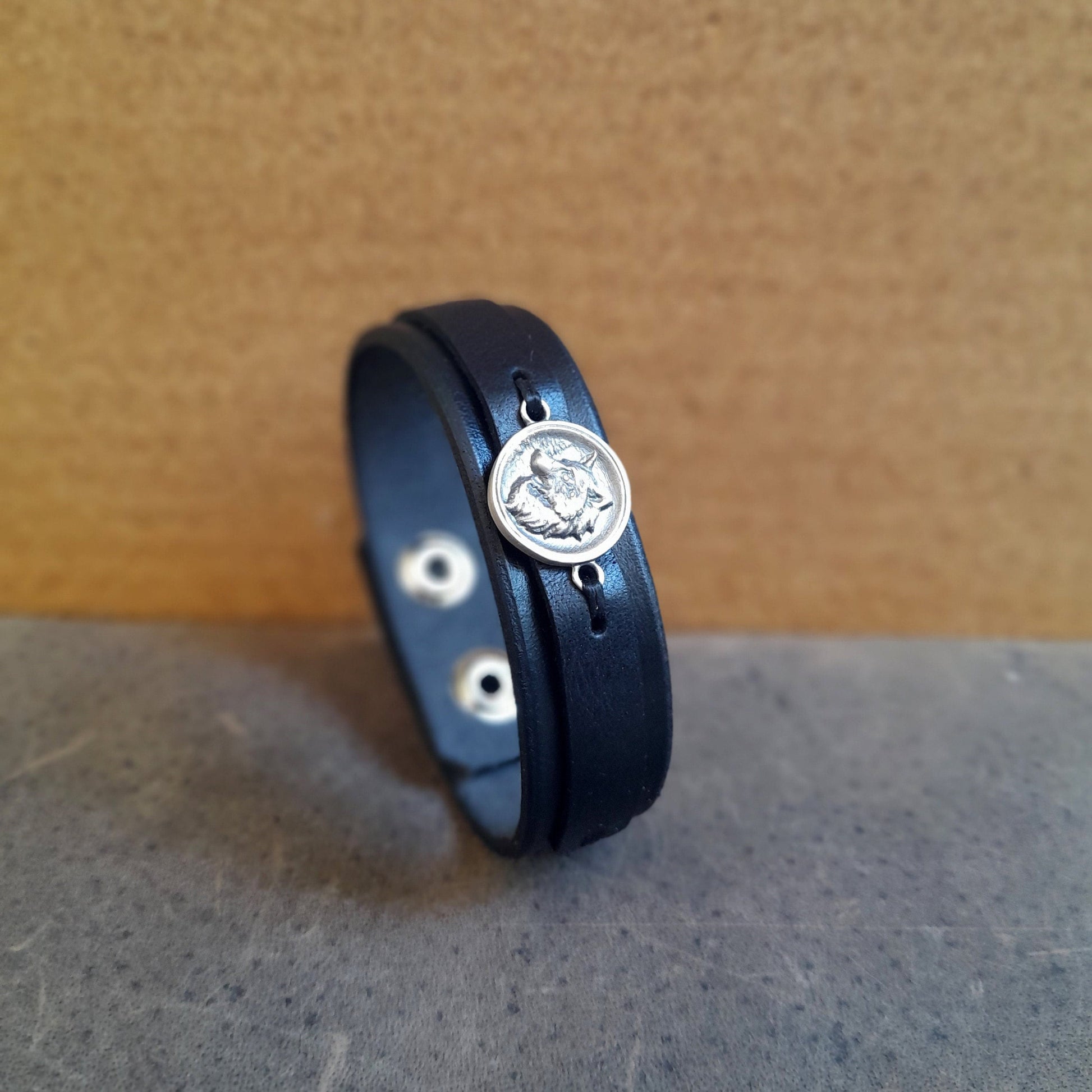 Layered black leather cuff bracelet with wolf symbol