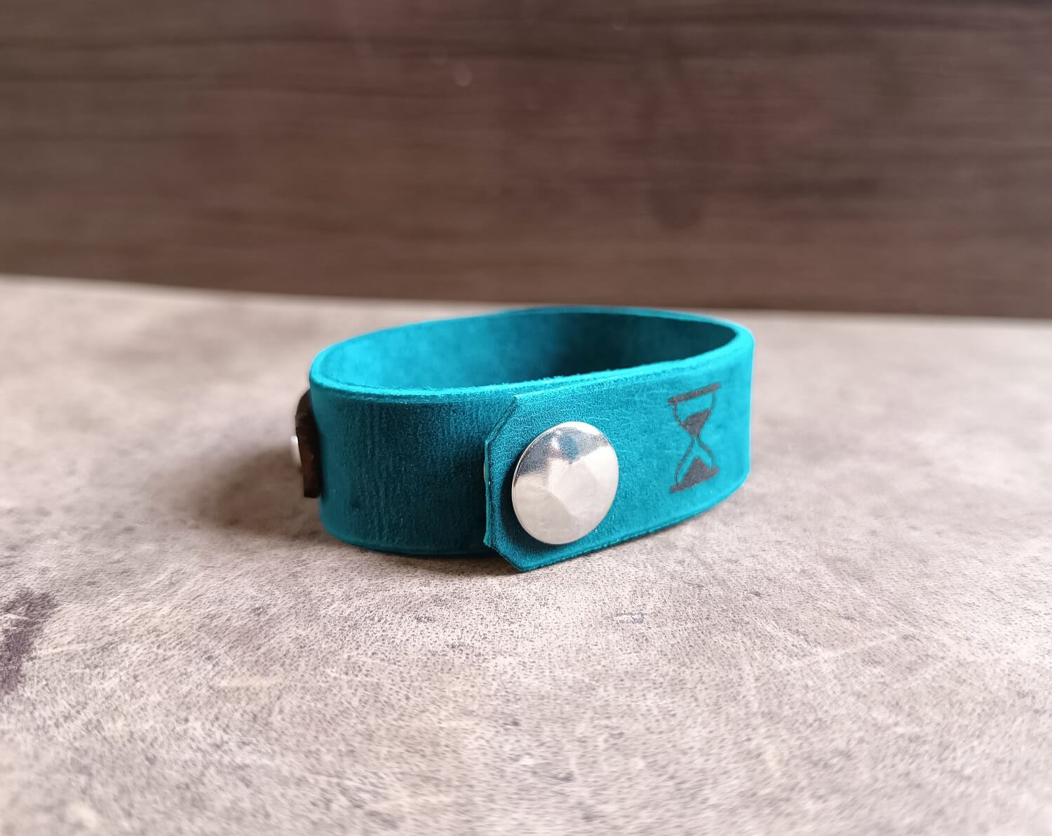 blue memento mori bracelet back view, showing snap closure and hourglass engraving