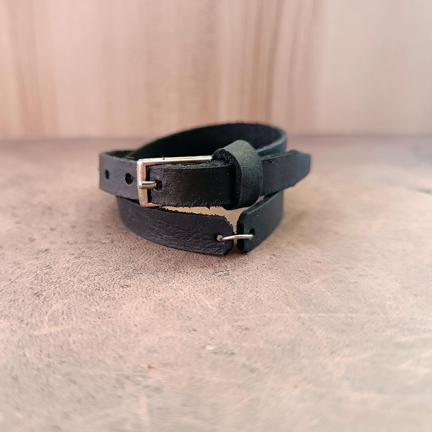 Detailed close-up of the robust stainless steel charm anchor on The Evolve Choker/Bracelet, highlighting the texture of the black Crazy Horse leather and the stainless steel buckle closure.