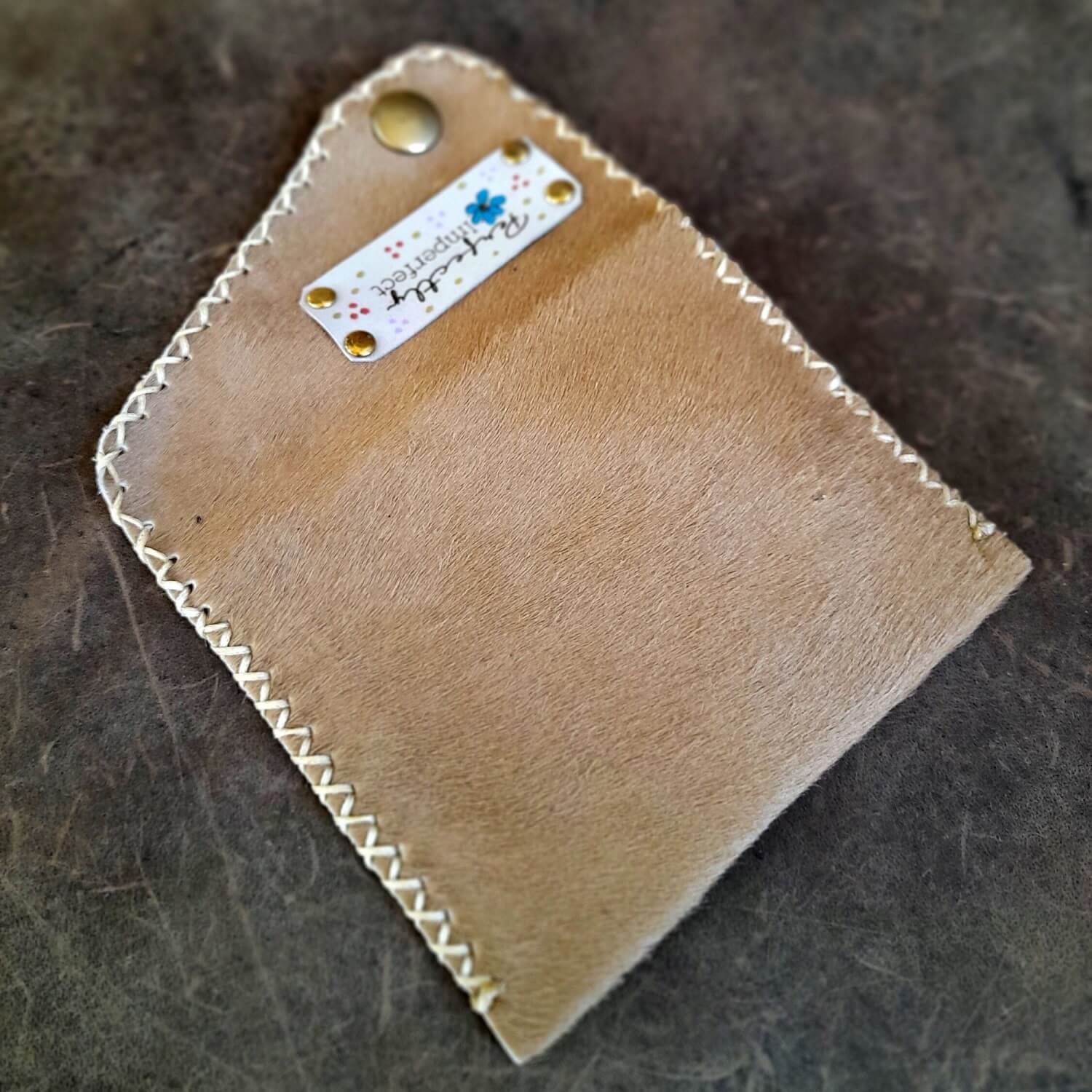 Detailed close-up of the pony skin hair on hide texture on the wallet, highlighting its natural patterns and soft feel.