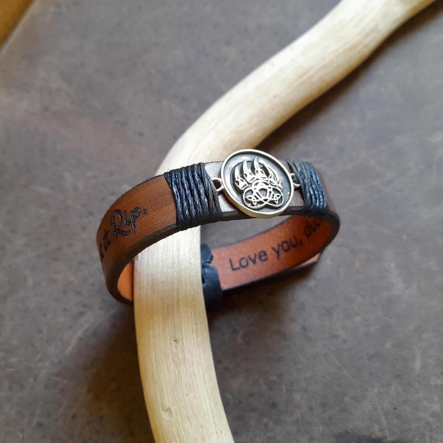 Close-up side view of the dark brown hand-dyed Crazy Horse leather on The Bear's Resolve Cuff, highlighting its rugged texture, and the distinct blackened and polished edges and striking pendant.