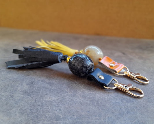 close up side angle of both tassel keychains