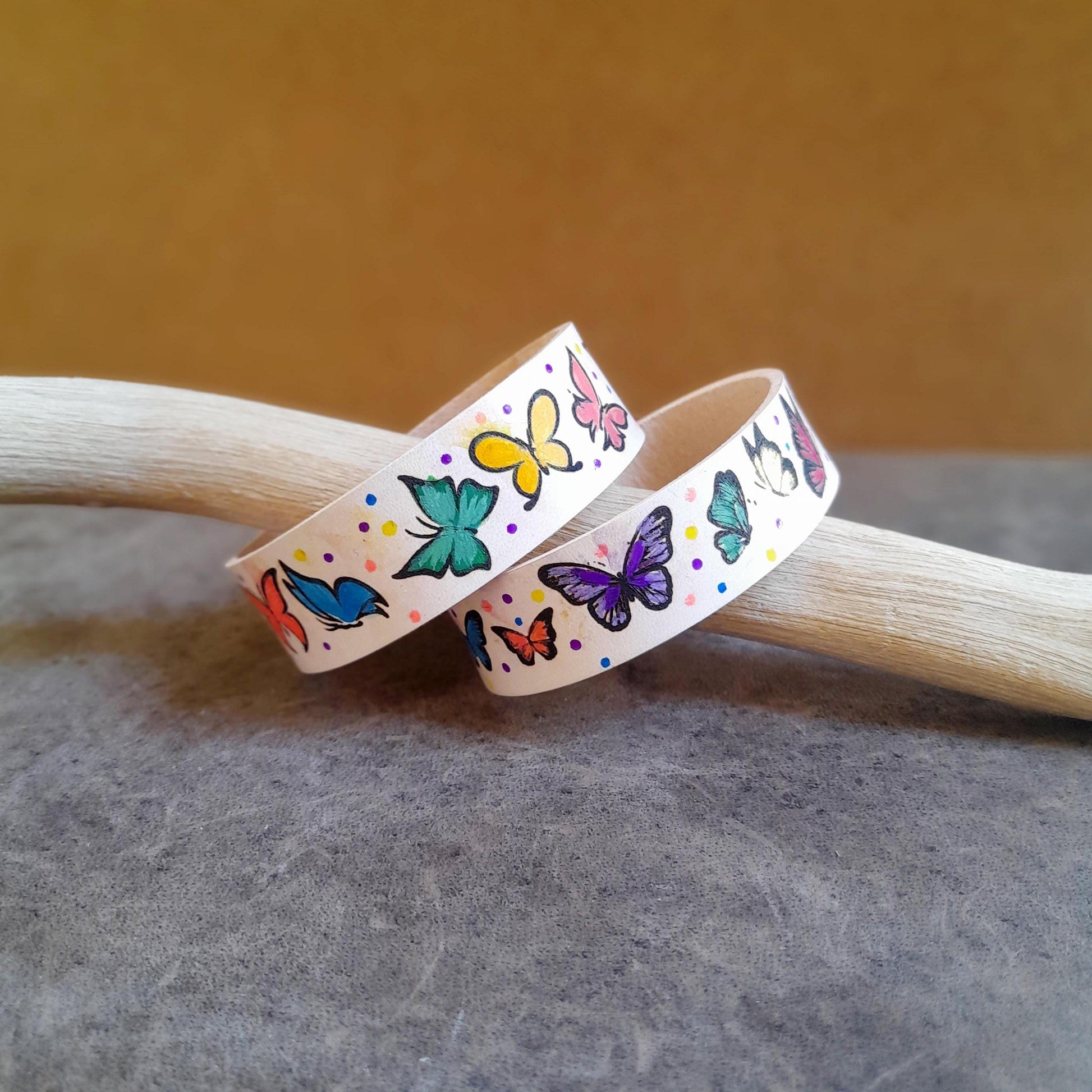 close up side view of the two hand painted butterfly bracelets