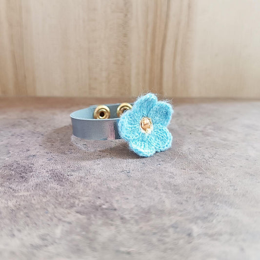 Bracelet with a blue flower charm on a neutral background