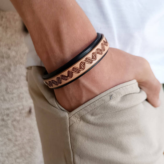 Close-up of a man's wrist wearing a black and brown Double Helix bracelet.