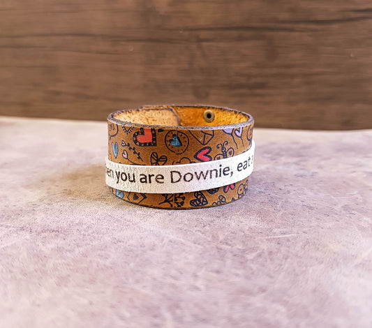 Leather bracelet with text and patterns on a wooden surface