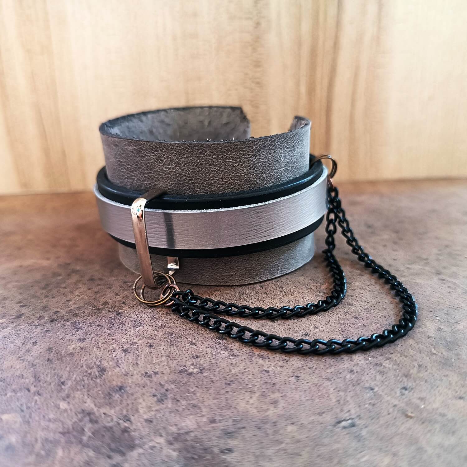 Leather bracelet with chain on a textured surface