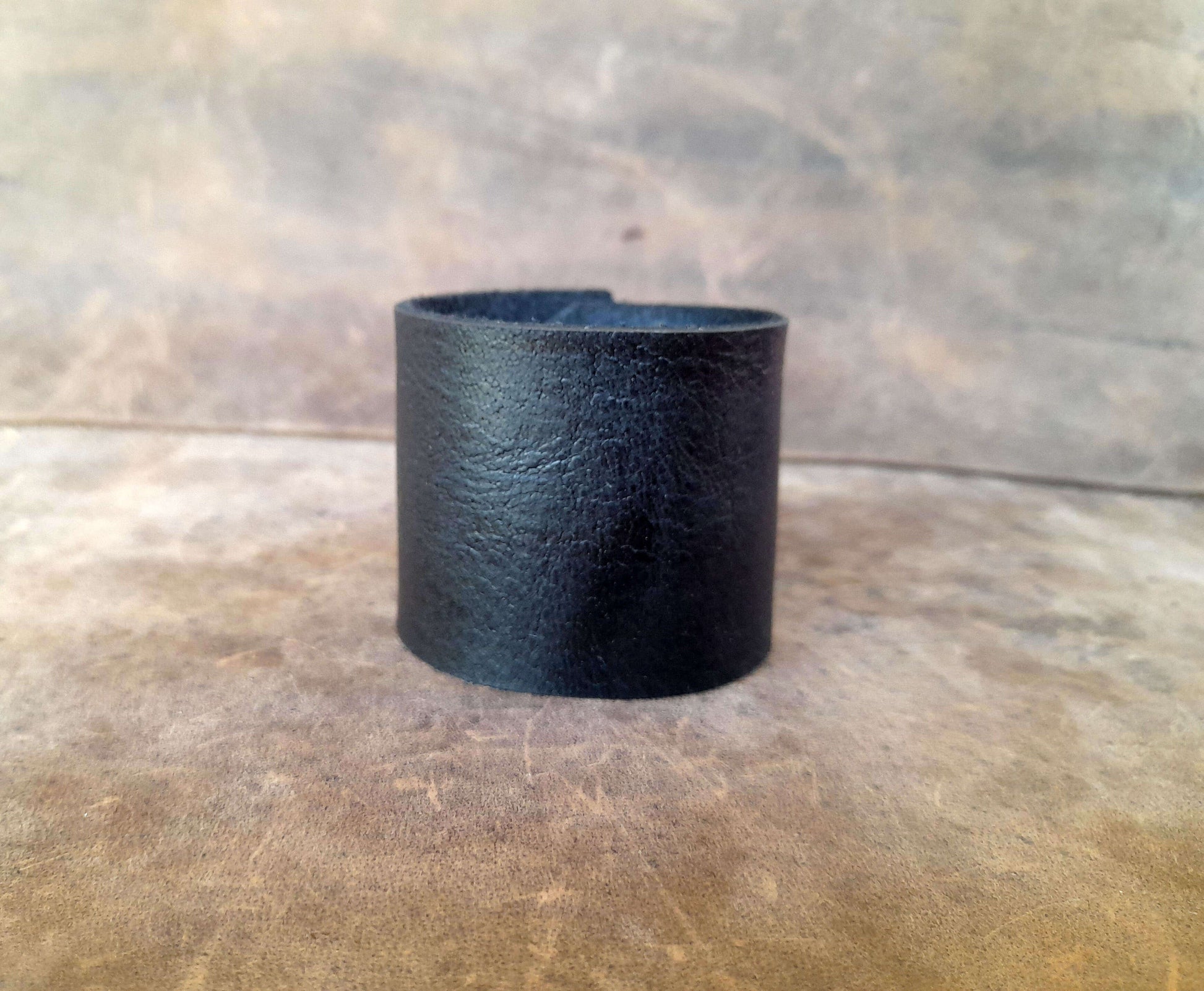 Black leather cuff on a wooden surface