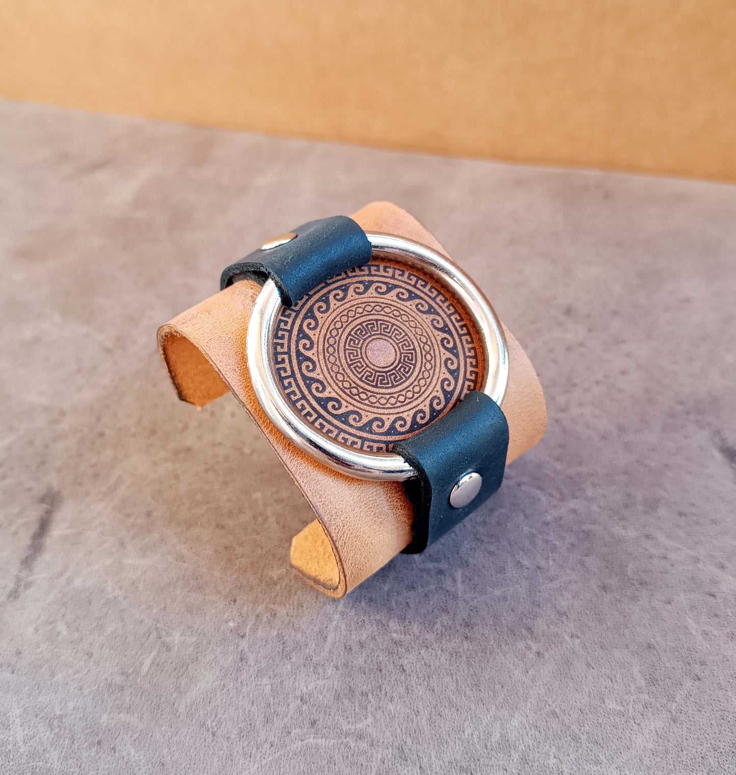 extra wide leather cuff with large metal ring and engraved greek motif