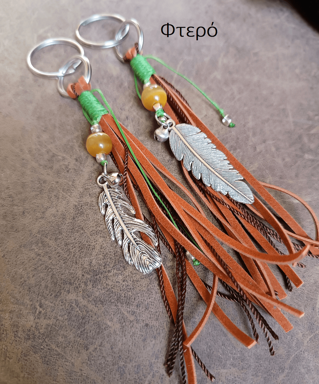Decorative keychain with feathers and tassels on a textured surface