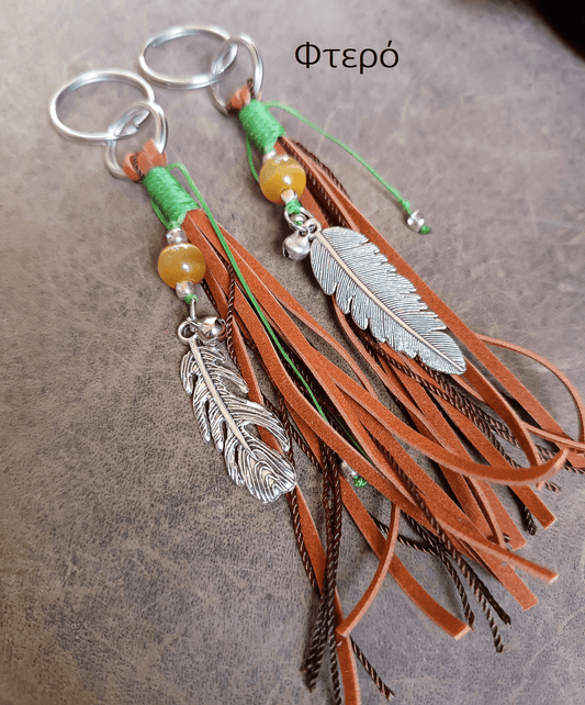 Decorative keychain with feathers and tassels on a textured surface