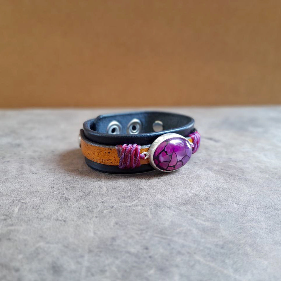 flat view of The Dragon Heart Bracelet: An OOAK leather cuff featuring a large Natural Purple Dragon Veins Agate cabochon set in hand-crafted Sterling Silver. Shows the full two-layered leather band.