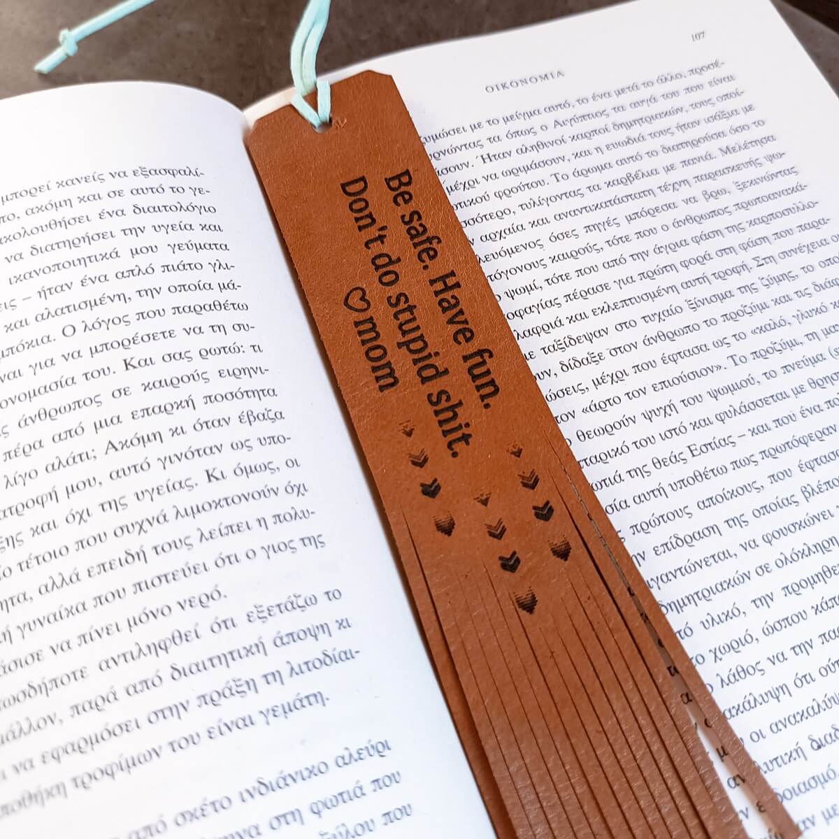 Brown leather bookmark with text on an open book