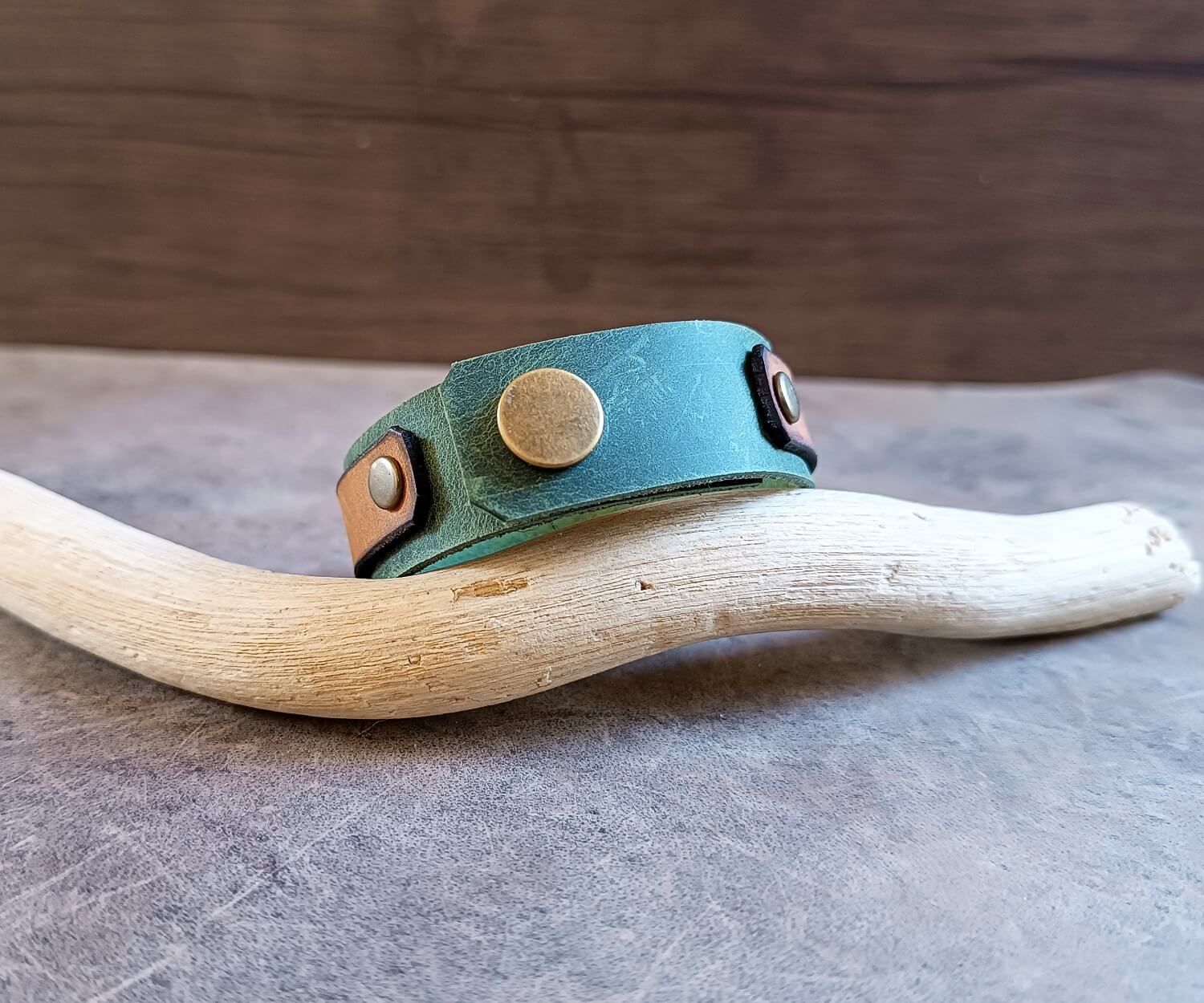 back side of the green leather cuff, showing the snap button closure