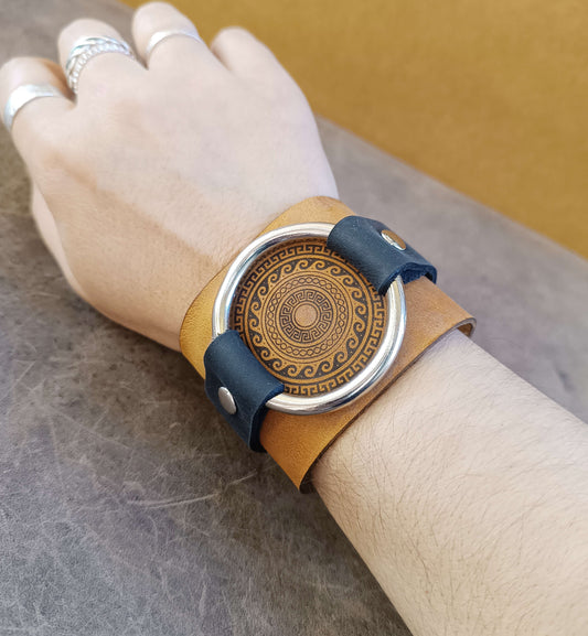 extra wide greek motif leather cuff worn on wrist