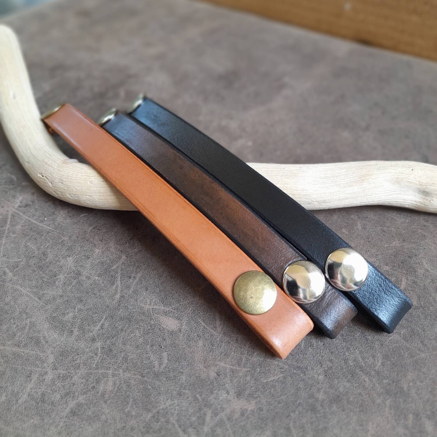 group photo of all three variations of the ringholder bracelet, laid flat open.