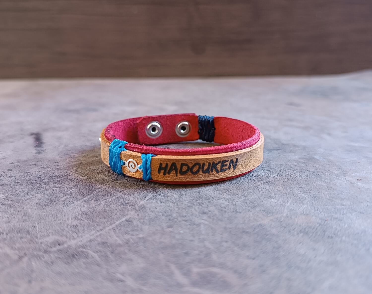 Leather bracelet with 'HADOUKEN' engraving on a wooden background