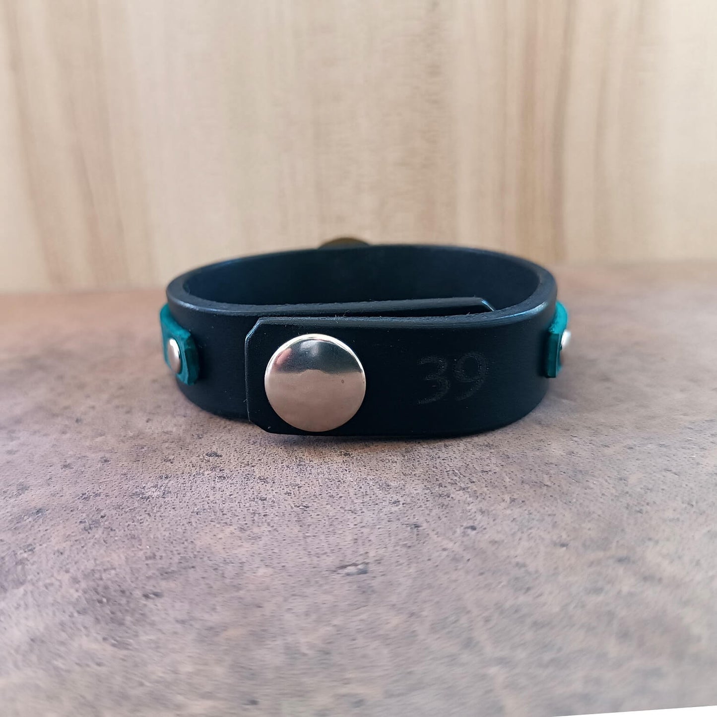 Bracelet with blue strap, pink accents, and gold Hatsune Miku pendant, backside view with "39" signature engraving