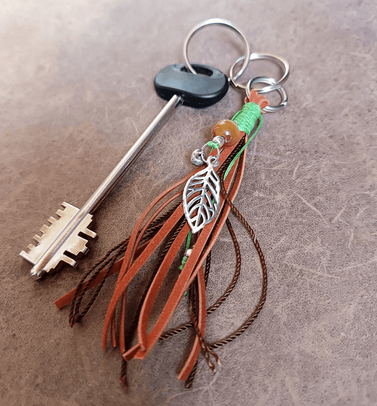 suede tassel keychain with leaf attached on key