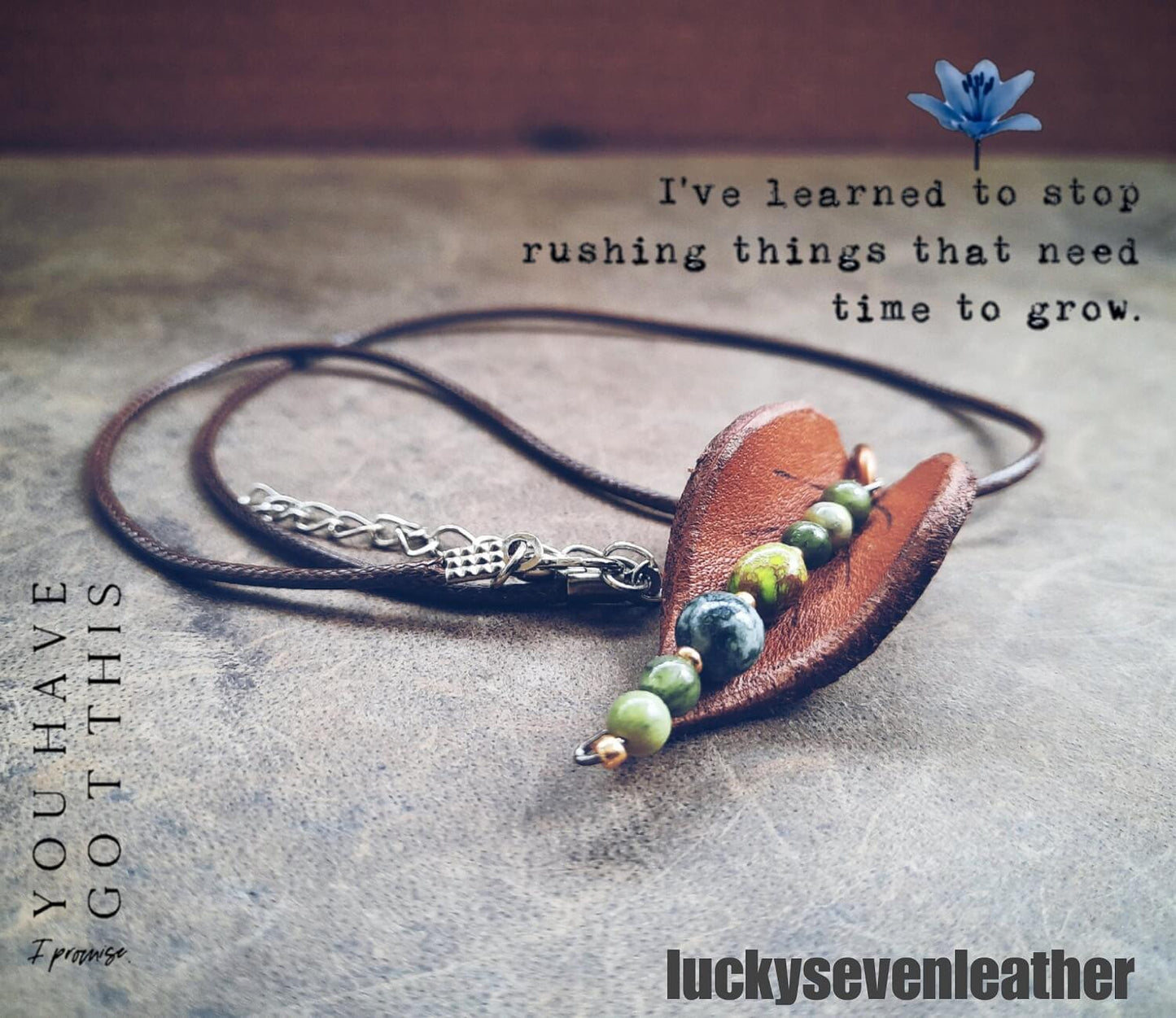 Hand-shaped leather leaf pendant necklace with Moss Agate and Green Jasper beads, on a dark background.