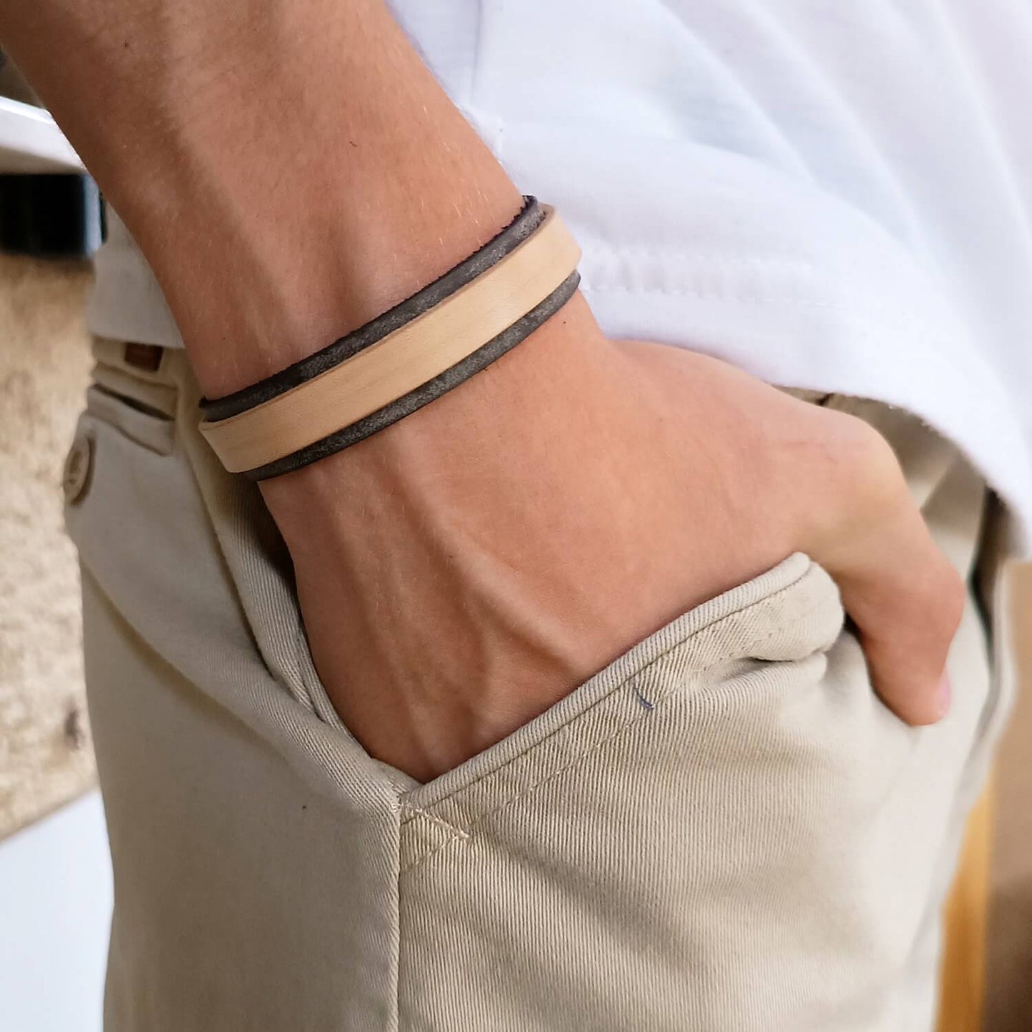 Close-up of a person's wrist wearing the Light and Shadow layered bracelet  with a neutral background.