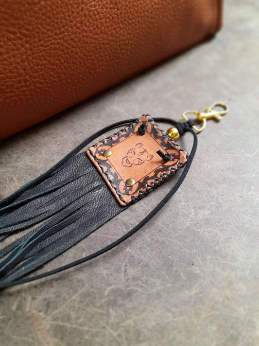 Leather keychain with fringes on a textured surface