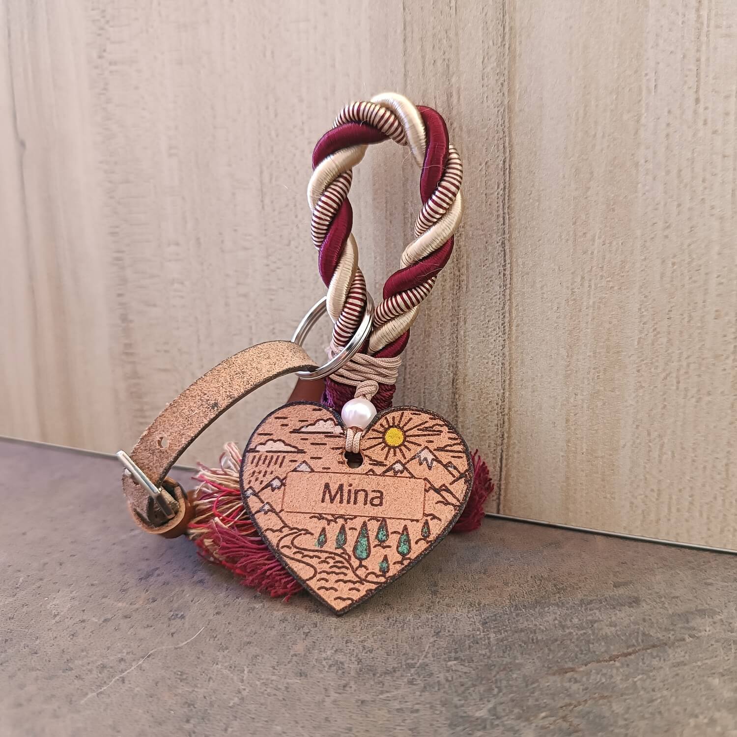 Heart-shaped keychain with 'Mina' engraving on a textured surface