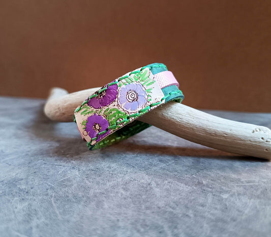 Floral-patterned bracelet on a wooden stick with a neutral background