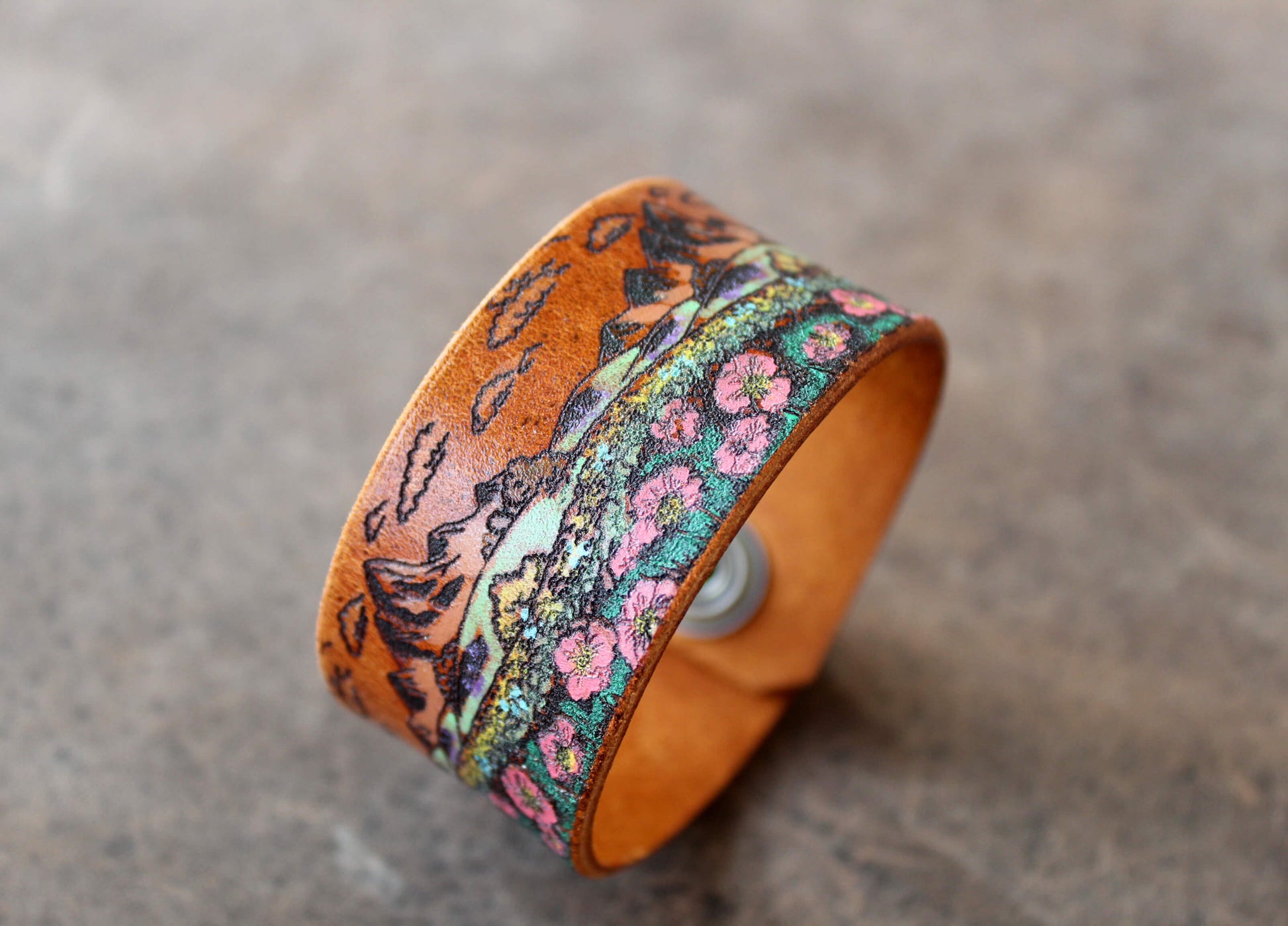 Leather cuff with floral pattern on a textured surface